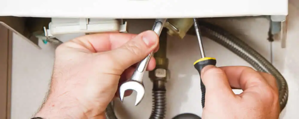 Boiler repair technician tightening pipe fittings and connections in Tacoma, WA