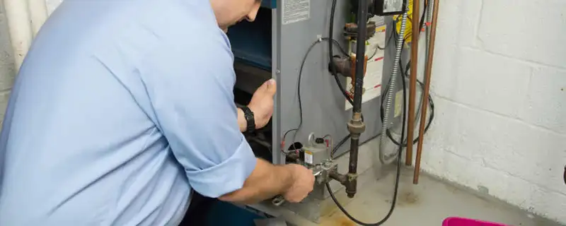 Furnace repair technician inspecting and servicing a home heating system in Tacoma, WA