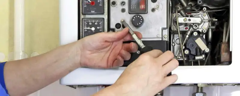 Heating repair technician adjusting boiler controls and components in Tacoma, WA