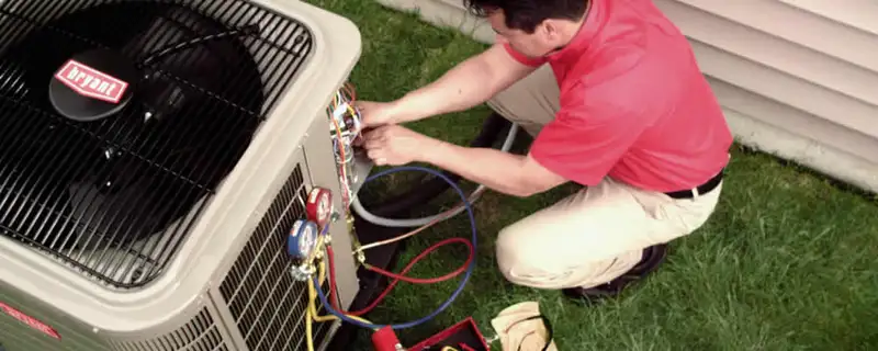 HVAC technician servicing an outdoor air conditioner unit in Tacoma, WA