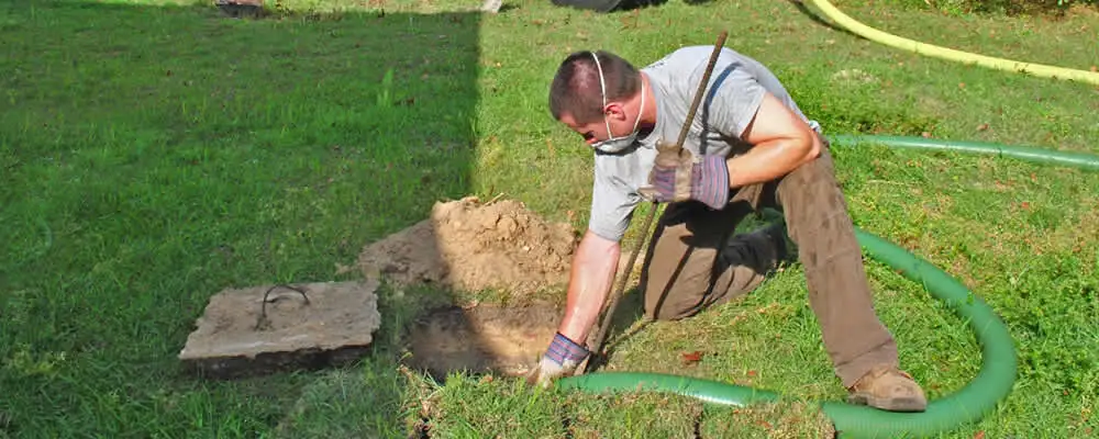 Septic pumping technician servicing a residential septic tank in Tacoma, WA