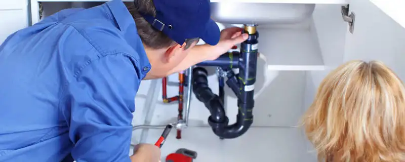 Plumber repairing under-sink drain pipes and fittings in Tacoma, WA